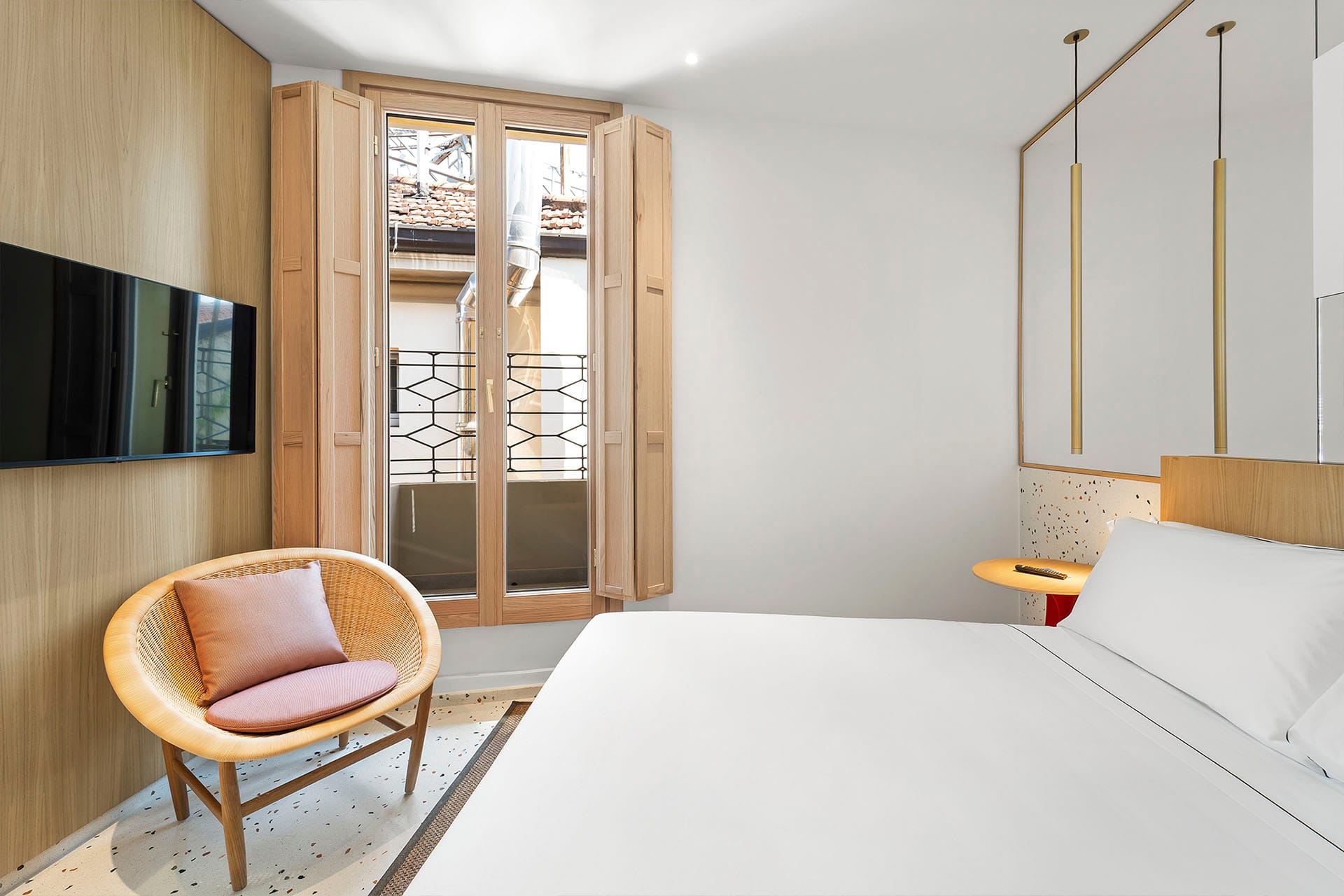 Detail of Prestige Quadruple Room with a king-size bed and flat-screen TV on the wall